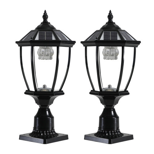 Set of two black ornate Victorian solar pillar lights on a white studio background