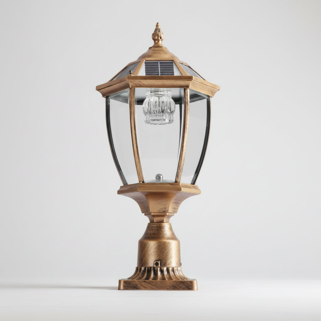 Antique gold solar post cap light on a plain studio background, showing the hexagonal lantern, tempered glass panels, solar cap and fluted metal base