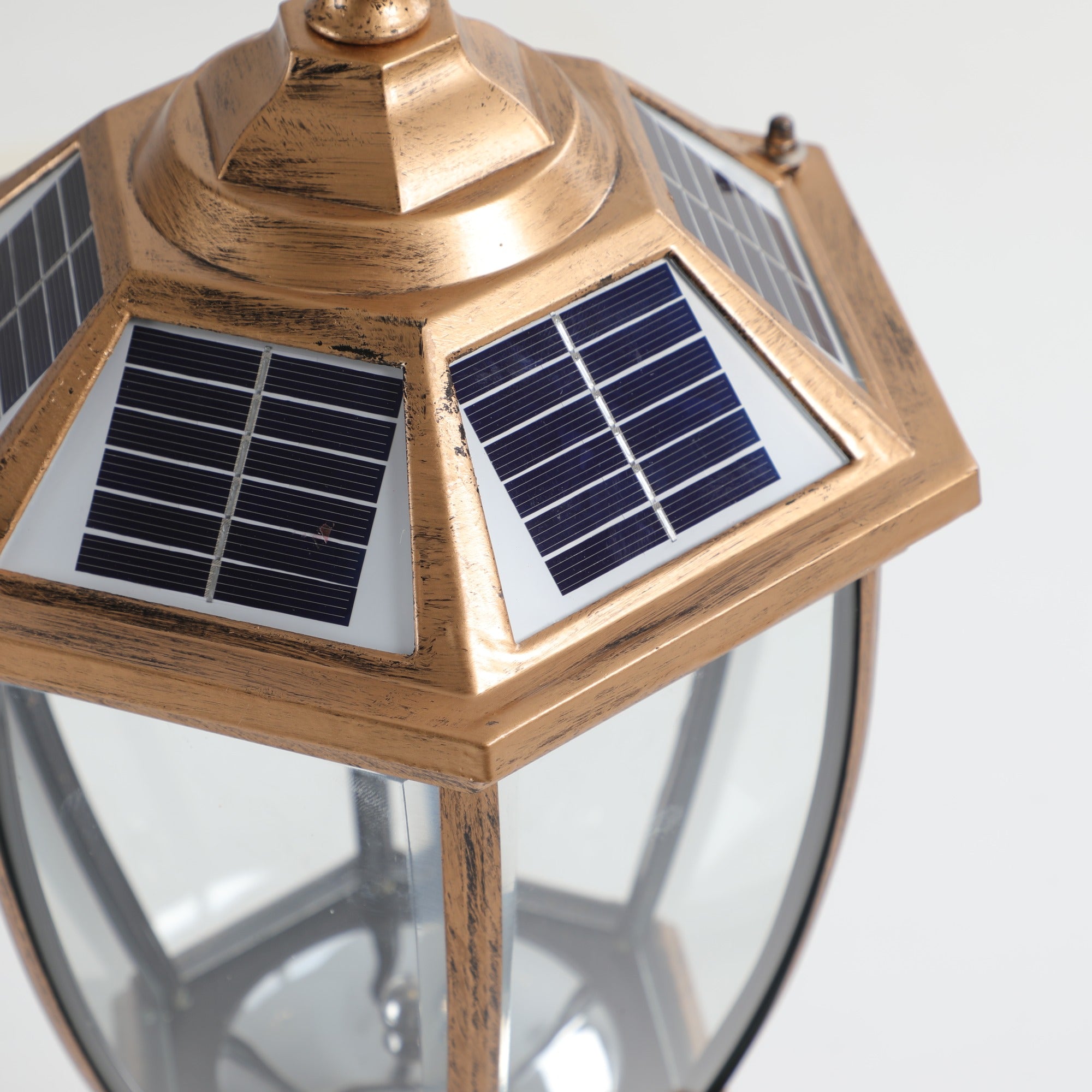 Close-up of the solar cap on the antique gold post light, showing the six solar panels set around the hexagonal roof